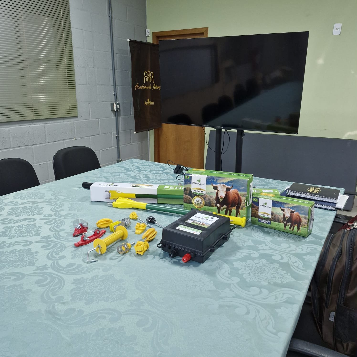 Mesa com produtos Pampeano para demonstração técnica — eletrificador e isoladores